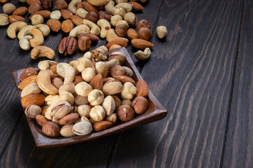 Cashew, almond, peanut, walnut nuts in a wooden bowl.