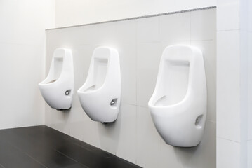public toilet clean modern white tiles urinal.