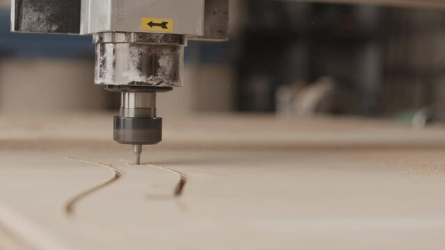 No people closeup of CNC router machine carving wood at woodworking factory