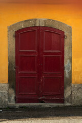 Old worn-out doors in a historic stone house of the 18th-19th centuries. Travel to European cities, southern Italy, old retro architecture