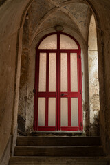 Obraz premium Old worn-out doors in a historic stone house of the 18th-19th centuries. Travel to European cities, southern Italy, old retro architecture