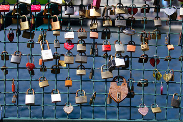 Love locks hanging at pedestrian bridge over River Limmat at the old town of Zürich on a sunny...