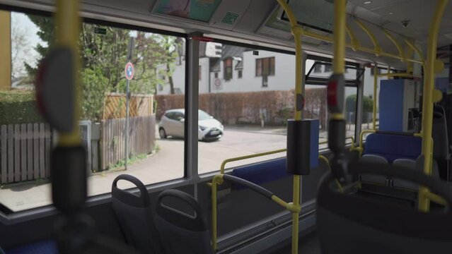 Interior of an empty bus with blue seats on a route in Munich. The topic of public urban transport in the Bavarian region of Germany. A line bus view of Munich