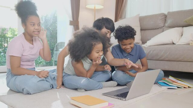 Happiness African family with mother and children using laptop computer watching video media online for learning and studying in the living room at home, mom teaching child, education concept.