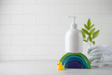  White plastic dispenser with baby cosmetic on a wooden rainbow. The concept of children's hygiene.