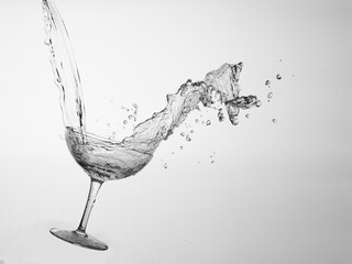 Splash im Champagnerglas vor Grau