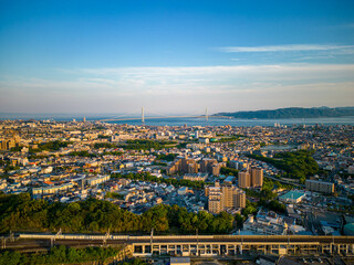 Fototapeta premium Late afternoon sun hits coastal city and suspension bridge