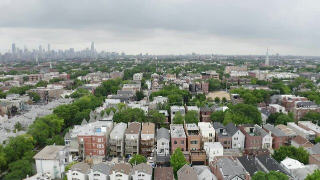 Drone Flying Away from Rows of Urban Houses in Chicago. Skyline in Background