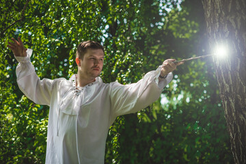 Man wizard with magic wand. Halloween concept, masquerade or cosplay Medieval look