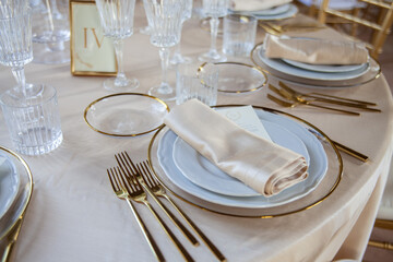 Hall of an ancient castle with catering for wedding events. The tables are set up with fine plates, glasses and cutlery