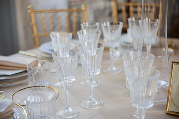 Hall of an ancient castle with catering for wedding events. The tables are set up with fine plates, glasses and cutlery