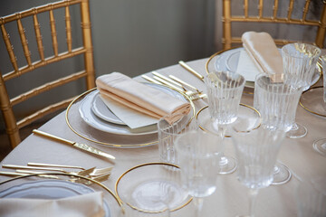 Hall of an ancient castle with catering for wedding events. The tables are set up with fine plates, glasses and cutlery