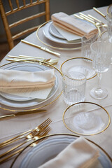 Hall of an ancient castle with catering for wedding events. The tables are set up with fine plates, glasses and cutlery
