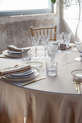 Hall of an ancient castle with catering for wedding events. The tables are set up with fine plates, glasses and cutlery