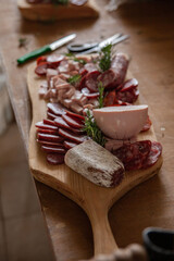 Cutting board with variety of typical Italian cold cuts and meats placed on the preparation table during a catering event