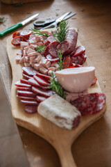 Cutting board with variety of typical Italian cold cuts and meats placed on the preparation table during a catering event