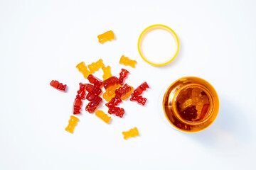 Children's vitamins in the form of bears an open jar on a white background. Top view, flat lay.