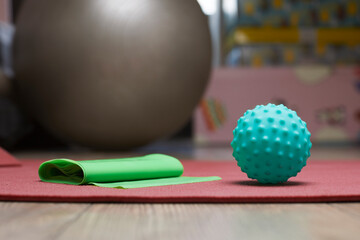Massage ball and rubber band for fitness lying on a yoga mat in the room