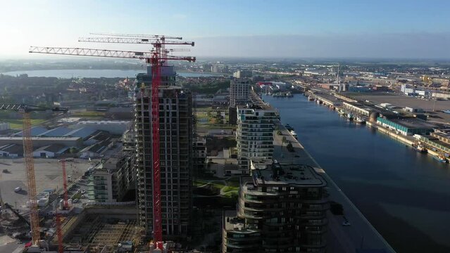 Drone flight over Belgian port city Oostende with harbor and beach in the morning