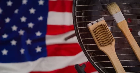 Fotobehang Grill / Barbecue Meerdere hulpmiddelen over barbecuegrill tegen Amerikaanse vlagachtergrond met exemplaarruimte