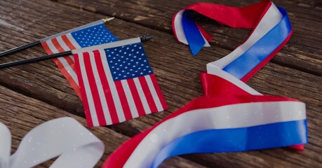 Twee miniatuur Amerikaanse vlaggen en linten op houten oppervlak met kopieerruimte