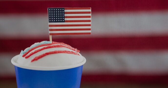Miniature american flag over a drink against american flag background with copy space