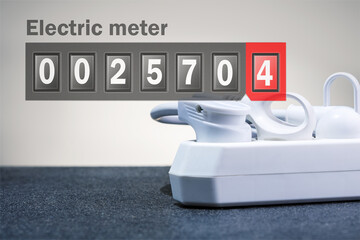 Electricity digital meter with electrical extension cord with plugs. Concept of  energy consumption.