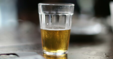 Close-up hand picking up beer glass at bar. Female hand picks ups glass beer