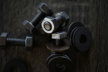 Closeup steel head bolts or nut with ring on a wooden floor.