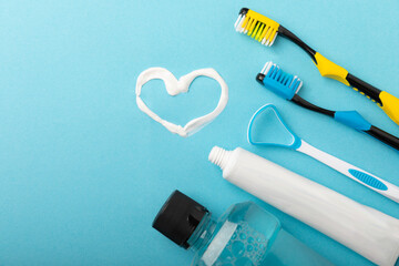 Heart symbol made from toothpaste. A tube of toothpaste and a toothbrush on a blue background....