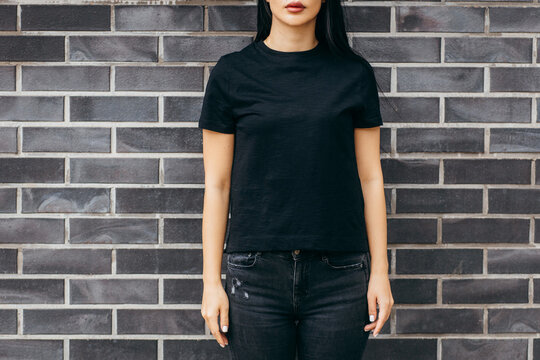 Stylish brunette asian girl wearing black t-shirt posing against street , urban clothing style. Street photography