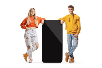 Trendy young guy and girl leaning on a big mobile phone
