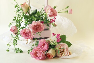 Obraz na płótnie Canvas Fresh pink roses in a basket, flowers on a light background, the concept of a romantic greeting, a bridal bouquet, invitations, weddings, a card, packaging or sale in a flower shop