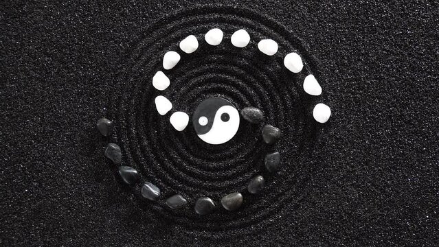 Japanese zen garden with yin yang stone in textured sand
