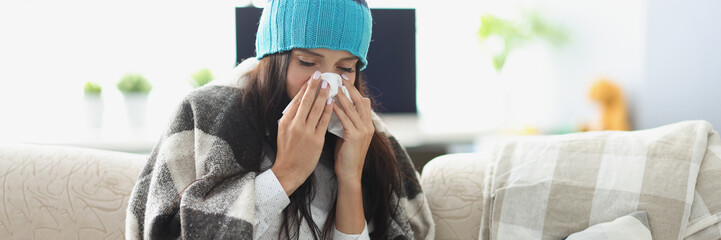 Sick woman having runny nose and use tissue covered with blanket