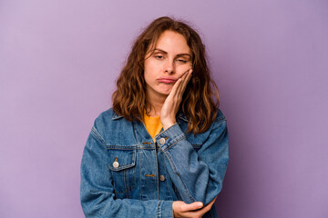 Young caucasian woman isolated on purple background who is bored, fatigued and need a relax day.