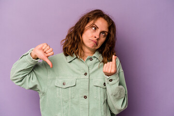 Young caucasian woman isolated on purple background showing that she has no money.