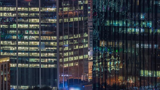 Night view of glowing windows in office building timelapse. High rise skyscraper with rows of lights in open space