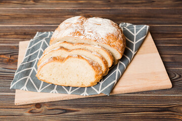 Assortment of freshly sliced baked bread with napkin on rustic table top view. Healthy unleavened bread. French bread slice