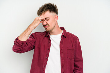 Young caucasian man isolated on white background having a head ache, touching front of the face.