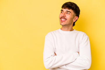 Young caucasian man isolated on yellow background smiling confident with crossed arms.