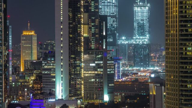 Aerial view of Dubai International Financial Centre district skyscrapers wit construction site night timelapse from downtown. Office towers from glass and hotels with modern buildings