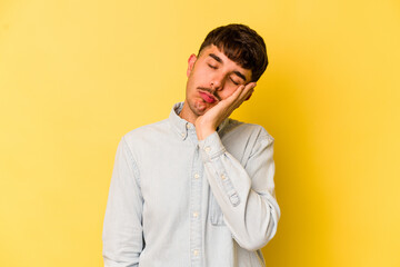 Fototapeta na wymiar Young caucasian man isolated on yellow background who is bored, fatigued and need a relax day.