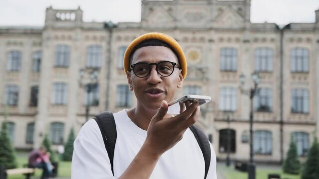 Motion portrait scene of a young hipster student talking on the phone in the middle of the campus