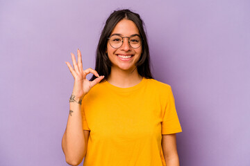 Young hispanic woman isolated on purple background cheerful and confident showing ok gesture.