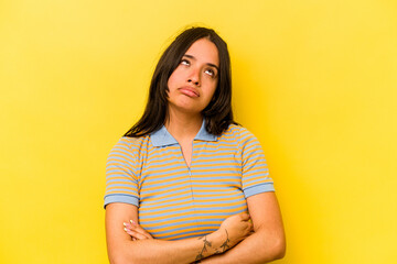 Obraz premium Young hispanic woman isolated on yellow background tired of a repetitive task.