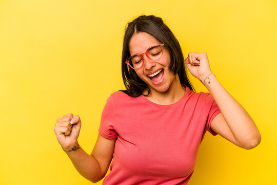 Young Hispanic Woman Isolated On Yellow Background Dancing And Having Fun.