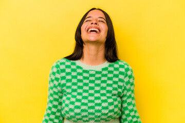 Young hispanic woman isolated on yellow background relaxed and happy laughing, neck stretched showing teeth.
