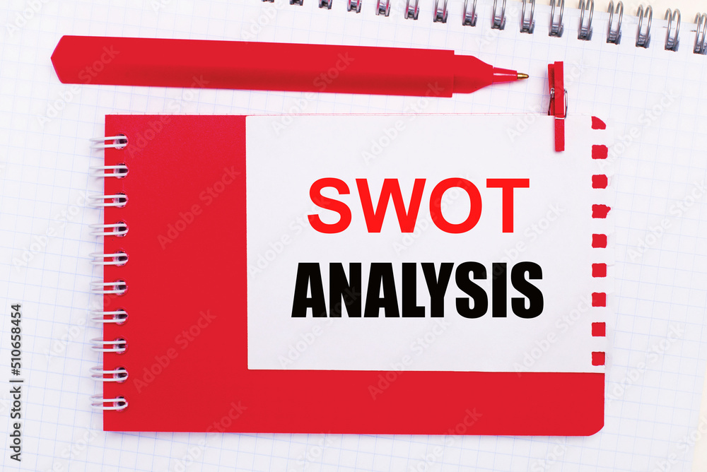 Poster on a white notepad, a red pen, a red notepad and a white sheet of paper with the text swot analysis
