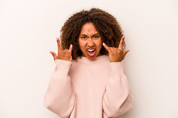Young African American woman isolated on white background showing a horns gesture as a revolution...